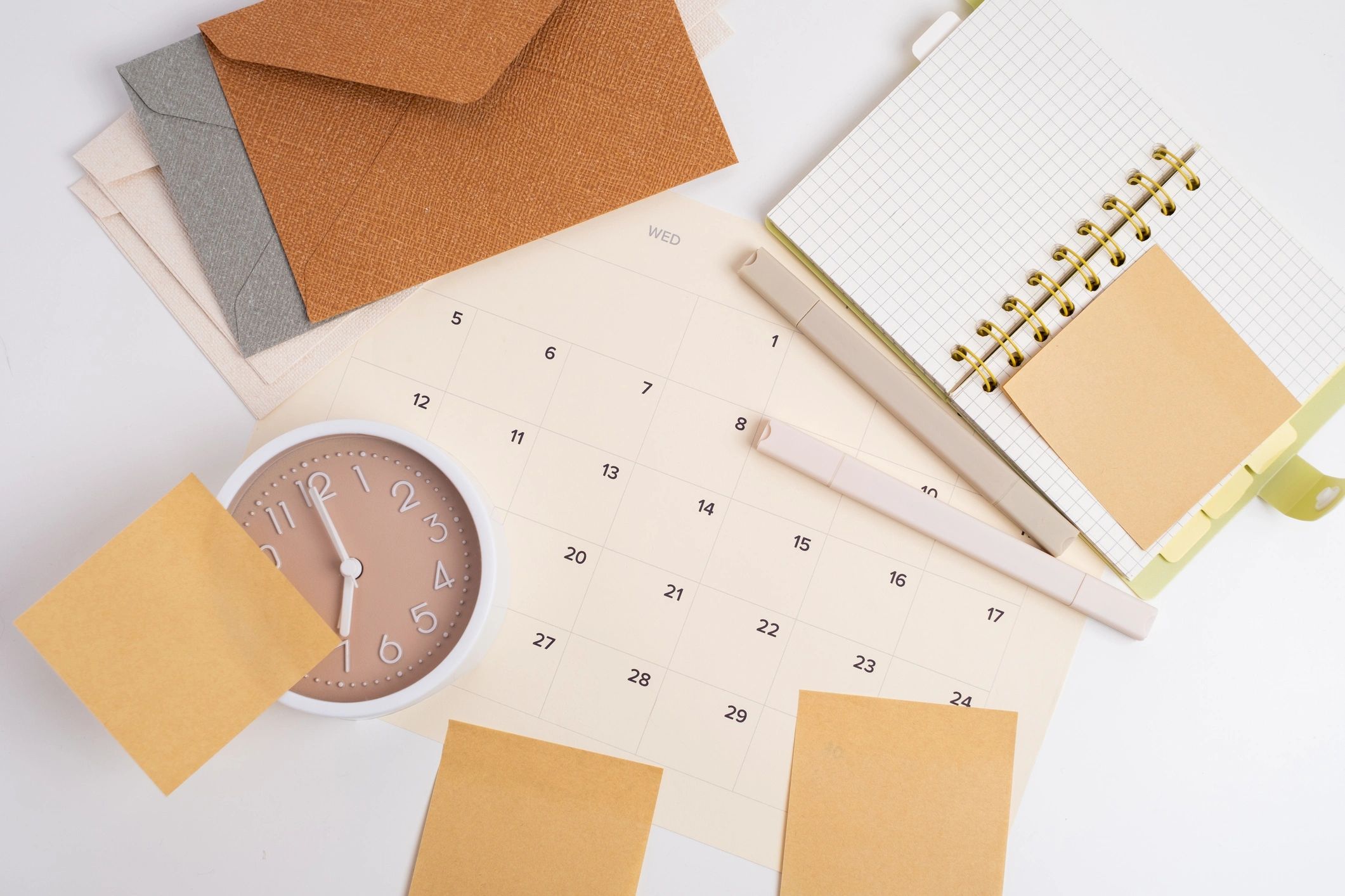 Calendar, notebook, and alarm clock with sticky notes on white background